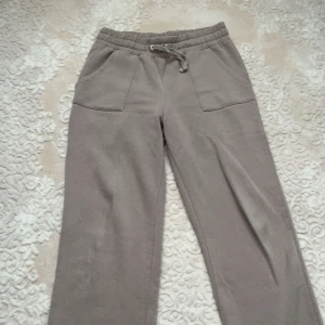 Beige mjukisbyxor med snörning - Säljer ett par beige mjukisbyxor med bred resår i midjan och snörning framtill. Byxorna har raka ben, två stora fickor fram och två bakfickor. Perfekta för chill dagar eller när du vill vara extra bekväm.🤎