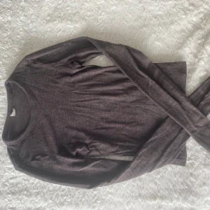 Brun långärmad tröja - En basic brun långärmad tröja i mjukt och tunt material. Perfekt att ha som lager eller bara till ett par jeans. Enkel rund halsringning och rak passform. Snygg och stilren för dig som gillar clean plagg.