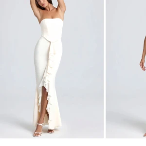 Vit långklänning Tallulah med volang - Supersnygg vit långklänning från Tallulah med axelbandslös design och figurnära passform. Klänningen har en cool volangdetalj längs slitsen framtill som ger extra edge. Perfekt för dig som vill sticka ut med en elegant och modern look.nypris 1399kr med tull säljes kanon pris 