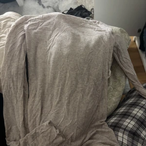 Beige långärmad topp från intimissimi - En basic beige långärmad tröja i mjuk bomull. Enkel och tunn modell med rund hals och avslappnad passform. Perfekt att styla med jeans eller under en jacka. Snygg neutral färg som funkar året runt.