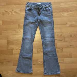 Grå bootcut jeans från Ginatricot - Snygga grå jeans från Ginatricot med bootcut-ben och klassisk femficksdesign. Jeansen har normal midja och är tillverkade i mjukt denimtyg.