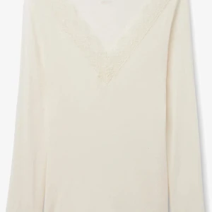 Vit långärmad blus med spets - Säljer en stilren vit blus med lång ärm och v-ringning dekorerad med fin spetskant. Perfekt för dig som gillar en enkel men ändå feminin look. Mjuk och skön känsla, passar till många outfits.