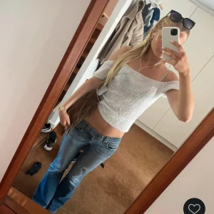 Vit offshoulder topp från Zara - Säljer en vit offshoulder topp från Zara i storlek S. Toppen är croppad och har ett vågigt, ribbat mönster i tyget. Materialet känns lätt och luftigt💗💗💗 (Första bilden är gamla ägarens bild!)