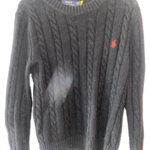 Svart kabelstickad tröja Polo Ralph Lauren - Svart kabelstickad tröja från Polo Ralph Lauren med klassisk röd logga broderad på bröstet. Varm nu när de börjar bli lite kallare. Pris går att diskutera vid snabb affär. 