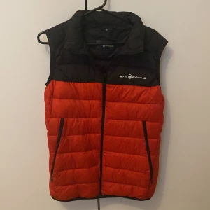 Sailracing Väst röd - Säljer just nu denna västen för endast 150kr den är i helt okej skick inget dåligt man skulle tänka på och storleken är 160 men jag är 165 och den passar fortfarande bra