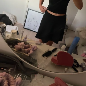 Svart kortkjol från 157 - Svart, enkel och flowy kortkjol från 157 med resår i midjan. Kjolen har en klassisk A-linjeform som ger en snygg siluett och passar perfekt till en basic topp eller hoodie. Superenkel att styla och ett måste i garderoben.