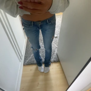 Bootcut jeans från Hollister, ljusblå - Säljer ett par ljusblå bootcut jeans från Hollister i modellen 'Boot'. Jeansen har slitna detaljer vid knäna, klassiska bakfickor med broderad söm och låg midja. Materialet är mjukt denim i bomull med lite stretch för skön passform. Fråga ifall mått önskas eller för fler bilder!💘ÖPPEN FÖR ALLA SORTERS PRIS FÖRSLAG!!