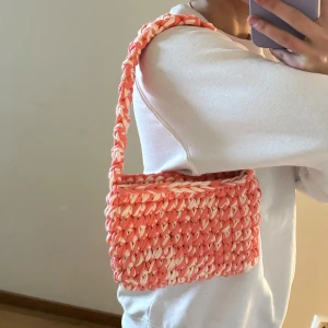 Virkad väska i aprikos - Hemmavirkad handväska, gjord i t-shirtgarn som är gjort av textilindustrins tygöverskott.   Mått: ca 22cm bred, 15cm hög och 38cm hög (inklusive handtag)