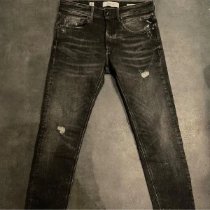 Snygga jeans från Replay - Svarta jeans från Replay med snygga slitna detaljer. Modell willbi sitter som anbass. Size 29/30, Nyskick!