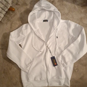 Vit Raplh lauren zip  - En Raplh Lauren zip i vit med en mörkblå Raplh Lauren logga på bröstet. Den är bra i stolken. 10/10 skick