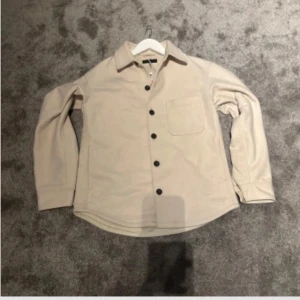 Overshirt - Säljer en stilren vit overshirt från Uniqlo. Helt oanvänd med tag kvar, nypris 849kr! Mitt pris 299kr, pris inte helt hugget i sten!