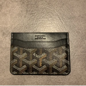 svart goy4rd korthållare - Snygg plånbok från goy4rd i svart skinn med det klassiska goy4rd-mönstret i brunt, beige och vitt. Slimmad design med flera fack för kort. Perfekt för dig som gillar exklusiva accessoarer med unik look. Bara att höra av skg vid funderingar, pris går att diskuteras👍😀