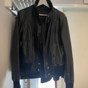 Skinnjacka  - Snygg men sliten skinnjacka. Välanvänd därav sprucket skinn här o där samt är dragkedjan till ena fickan lite trög, annars bra skick. Slim fit med knappar och dragkedja. Säljer då den inte är min stil och inte används. Hör av er för frågor! 💗