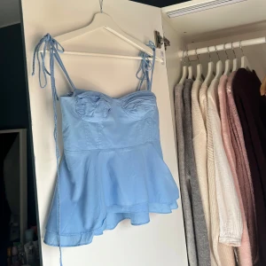 Ljusblå Zara topp - Så fin Zara topp med volang längst ner. Storlek S och väldigt bra skick. Längden på banden går att justera. En liten fläck som visas på sista bilden men är knappt märkbar. Skriv vid frågor eller köp direkt💗