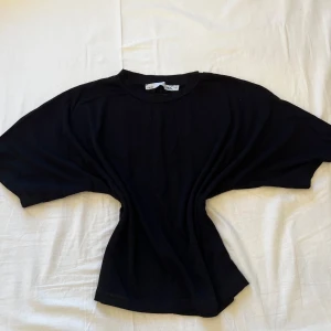 Svart loose topp med vida ärmar - En svart topp från Lager 157 med loose passform och extra vida korta ärmar. Toppen har rund halsringning och är tillverkad i mjuk bomull, perfekt för en chill och avslappnad stil. 💞