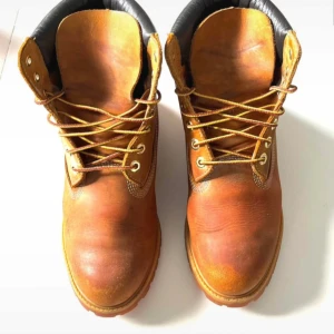 Timberland Kängor, Brun, Storlek 42-42,5 - Ett par klassiska bruna Timberland kängor. Perfekt för höst och vinter endel använd dem året runt. Bekväma och tåliga kängor som passar till många olika outfits. Mindre skador,repor,slitage kan finnas ,Inga skador som påverkar funktionen ,Kängorna är inte nya men i sin helhet gott skick. Passar Män och kvinnor. ordpris:2295kr Bilderna togs personligen av mig, vilket säkerställer att du ser exakt den produkt du köper.Vänligen observera att jag inte har någon öppetköp. Skickar endast med PostNord.
