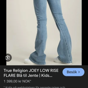 Blå flare jeans True Religion - Snygga blå jeans från True Religion med låg midja och utsvängda ben. Klassisk femficksmodell i mjukt denimtyg, perfekt för dig som gillar retrovibbar och vill sticka ut. Passar grymt med sneakers eller boots.
