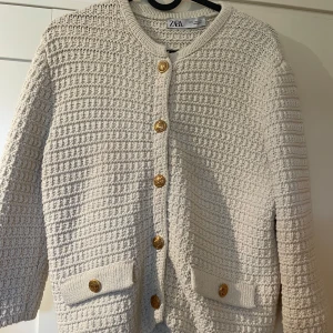 Beige trekvartsärmat kofta - Jättefin kofta som man kan ha både öppet eller stängt, använd fåtal gånger. Från Zara som inte finns i sortimentet längre, de guldiga knapparna är hela och har inte tappat färg, strl L men passar som S/M