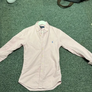 Rosa skjorta från Polo Ralph Lauren - Säljer en stilren rosa skjorta från Ralph Lauren i slim fit. Skjortan är i mycket bra skick och har änvänt 1gång och är storlek xs