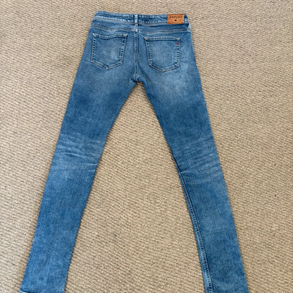 Snygga blå jeans från Replay med en klassisk femficksdesign och knappgylf. Perfekta för en avslappnad stil. Märkeslogga på bakfickan ger en extra touch.. Farkut & Housut.