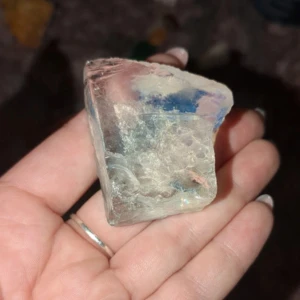 Opal - Säljer en stor och klar kristall med en vacker regnbågseffekt. Perfekt för samlingar eller som en dekorativ detalj i hemmet. Kristallen har en rå och naturlig form som ger den en unik karaktär.