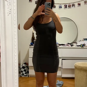 Svart tight jeans klänning - Snygg svart/mörkgrå tight jeans klänning med smala axelband och dragkedja på sidan. Perfekt för en kväll ute eller en speciell tillställning. Klänningen har en enkel och stilren design som framhäver figuren.