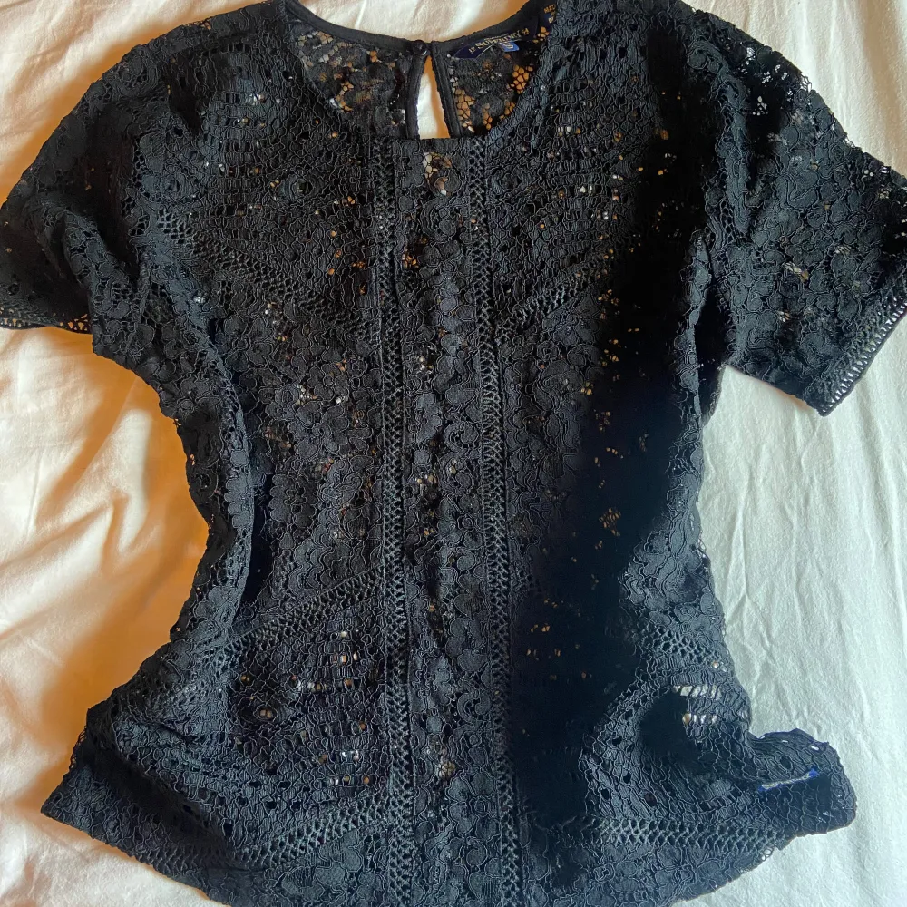 Säljer en elegant svart spetsblus från Superdry. Blusen har ett vackert blommönster och är perfekt för en stilren look. Fick från min mamma för något år sen så finns inte kvar på marknad längre ❤️ Spetsen är väldigt tjock och ordentlig så extreamt svårt att tröjan ska skadas eller gå sönder. Blusen är i storlek S från Superdry 😚😚. Yläosat.