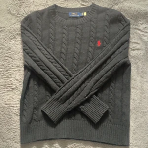Svart Kabelstickad tröja från Polo Ralph Lauren - Säljer en stilren svart stickad tröja från Polo Ralph Lauren. Tröjan är använd 3-4 gånger och har inga defekter. 😁🙌