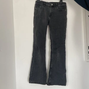 Svarta flare jeans - Snygga svarta flare jeans i denim med mid waist. Perfekta för en trendig look med sin utsvängda stil. Passar bra till olika outfits och ger en cool touch till garderoben.