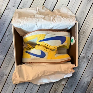 Travis Scott Air Jordan Canary  - Säljer dessa helt nya Air Jordan 1 Low x Travis Scott i modellen Canary (Women’s). I svensk herrstorlek motsvarar de ungefär storlek 45.  Skorna är köpta från SNKRS, och originalkartong samt skosnören medföljer (se sida 3). Dock har kartongen en mindre skada på kanten (se sida 5).  Dessa skor är för den modiga, men samtidigt riktigt eleganta och perfekta för sommaren!