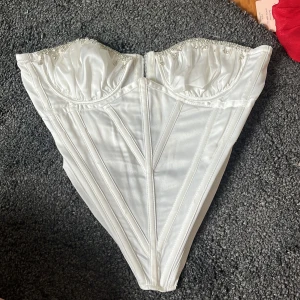 Vit korsett med pärldetaljer - Såå fin vit korsett med pärldetaljer vid bysten och dragkedja framtill. Aldrig använd! 💕