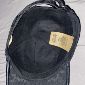 Grå keps med mönster - Snygg grå keps med ett distinkt mönster i svart. Kepsen har en klassisk design med rundad skärm och justerbar rem baktill för perfekt passform.