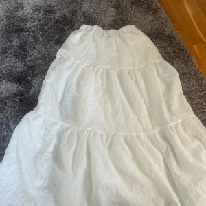 Vit långkjol i bomull - Säljer en luftig och bekväm vit långkjol i bomull. Kjolen har en elastisk midja och flera lager som ger en fin volym. Perfekt för varma sommardagar eller en avslappnad stil. Hör av dig vid intresse! 🌼köpt här på plick för 400 säljer för 300♥️knappt använd 