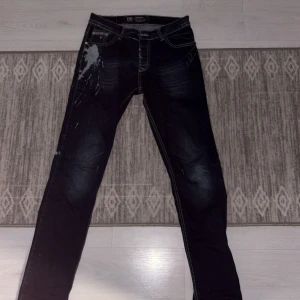 Jeans  Diesel - Snygga mörkblå jeans från Diesel med slitna detaljer och en cool tvätt. De har en klassisk femficksdesign och en knappgylf. Perfekta för en avslappnad stil med en touch av edge.