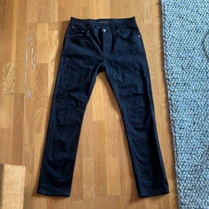 Svarta jeans från Nudie Jeans - Svarta jeans från Nudie Jeans med en klassisk design. De har en normal passform och är tillverkade i ett slitstarkt material.