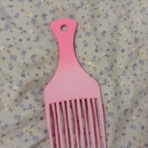 Rosa hårkam med extra lyft - En rosa hårkam från Good Hair, designad för att ge extra volym och lyft till håret. Perfekt för att styla och skapa voluminösa frisyrer. Kammen har en praktisk hål för upphängning.