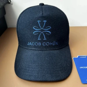 Jacob Cohen Keps - Säljer denna sjukt eftertraktade kepsen i mörkblå färg frän Jacob Cohen! Köpt pa farfetch för 240 euro motsvarande - 2449 kr, saljer for ett sjukt pris. Sparsamt använd och är i ett mycket fint skick. Den är i en ull blandning. Sjukt stilren! Hör av dig för fler frägor eller bilder:)