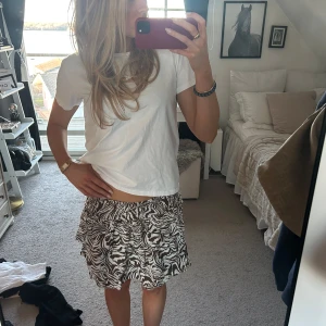 Zebramönstrad kortkjol - Snygg kortkjol med zebramönster i brun och vit. Kjolen har volangdetaljer som ger en trendig look. Perfekt för att liva upp garderoben med ett en cool kjol💕💕