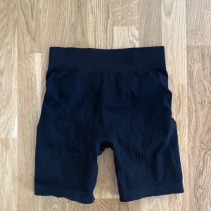 Svarta ribbade cykelshorts från Bo+tee - Säljer ett par svarta ribbade cykelshorts med hög midja. Perfekta för träning eller en avslappnad dag. De är stretchiga och bekväma, vilket gör dem till ett måste i garderoben. Vet inte vilken strl tyvärr, men skulle gissa på S eftersom de passar mig som vanligtvis är en S🥰