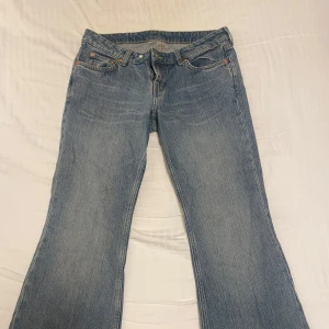 Blå bootcut jeans - Säljer ett par klassiska blå bootcut jeans från Weekday (Nova low slim bootcut) i storlek 29/32