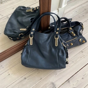 Marinblå Väska - Så himla snygg vintage väska💛 passar till allt och är väldigt rymlig, min favvo!! Köpt här på Plick för 500kr, ganska sliten på baksidan och undersidan av väskan, jag brukar ha den slitna sidan inåt så att det inte syns💓 (se bild 4&5) skriv vid frågor eller om du vill ha ett annat pris!