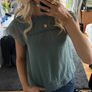 Grön blus med spetsdetaljer - Säljer en söt grön blus med korta ärmar och spetsdetaljer. 