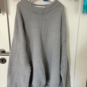 Oversized grå stickad tröja - Mysig oversized stickad tröja i ljusgrått med bred ribbad halsringning