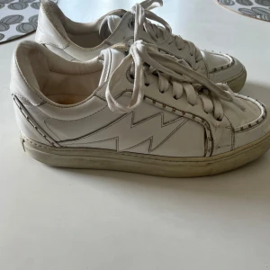 Vita sneakers från Zadig & Voltaire - Snygga vita sneakers från Zadig & Voltaire! De är i bra skick förutom att de är lite slitna på hälkappan men badet är bara ytligt 💗Nypris 3000kr. Pris kan diskuteras 