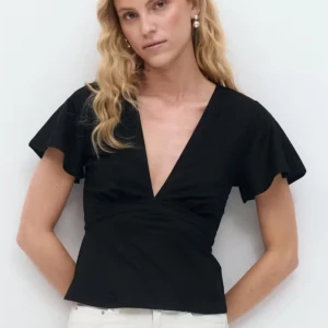 Svart Tie Top  från Gina Tricot - Svart omlottopp från Gina Tricot med djup v-ringning och korta, fladdriga ärmar. Toppen har knytband i midjan som ger en snygg siluett. ALDRIG ANVÄND. Tillverkad i mjuk bomull som känns skön mot huden. Perfekt att styla med jeans eller kjol för en cool look.