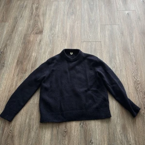 Mörkblå stickad tröja med rund hals - En enkel och stilren mörkblå stickad tröja med rund hals och långa ärmar från arket, storlek m och passar 180cm.