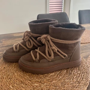 Bruna inuikki skor - Säljer ett par bruna Inuikii med mjuk insida och grova snören. Skorna är i mocka och skinn, har rund tå och platt sula. Bra skick och är använda sparsamt. Köpta nya från NK för 3000kr. Säljer då de tyvärr är lite för stora för mig. 