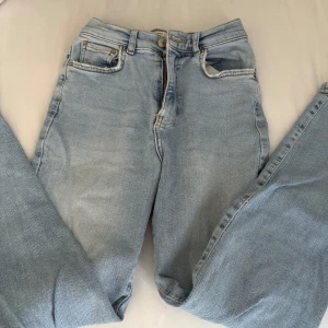 Ljusblå jeans från Perfect Jeans - Säljer ett par ljusblå jeans från Perfect Jeans i storlek 34. Klassisk femficksmodell med raka ben och normal passform. Jeansen har hög midja och är tillverkade i mjukt denimtyg med snygga sömmar och detaljer. Perfekt för en chill och stilren look.