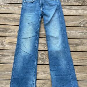 Blå flare jeans från Pepe Jeans - Snygga blå jeans från Pepe Jeans med flare-ben och klassisk femficksdesign. Jeansen har midwaist och är tillverkade i mjukt denim med lätt tvättad look. Bakfickorna har broderad detalj. Endast använd någon fåtal gånger. Storlek: 27/30 (nypris:700kr)