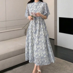 Vit och blå långklänning med blommigt mönster - Supersöt långklänning från Shein i vitt och ljusblått med blommigt mönster. Klänningen har korta ärmar, knappar framtill och ett lätt, luftigt material som känns perfekt för varmare dagar. Den har en avslappnad passform och markerad midja.